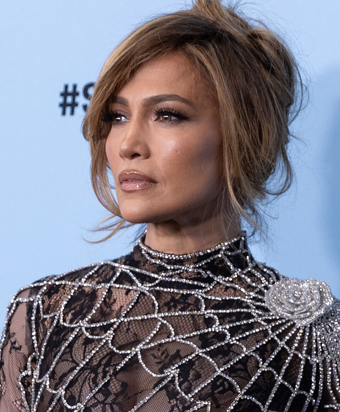 Jennifer Lopez in a sparkling gown, a famous face revealing Hollywood secrets.