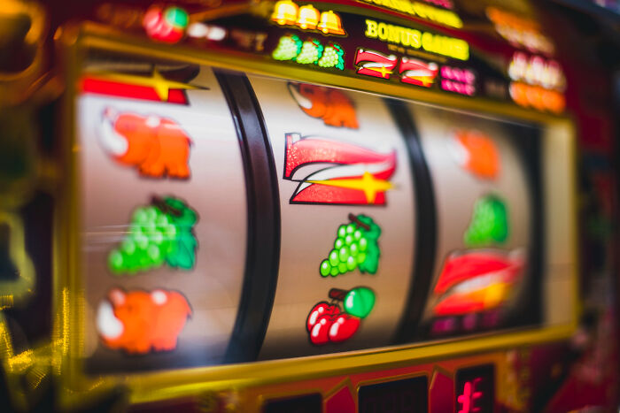 A close-up of a slot machine with flashing lights, representing dumb ways people ruin their lives through gambling.