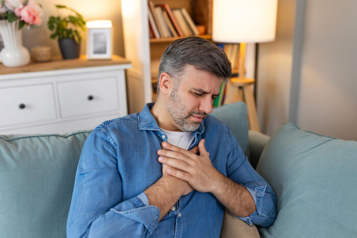 A man clutches his chest in discomfort, reflecting on an unexpected end to a life story.