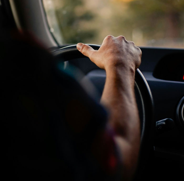 A hand gripping a steering wheel, representing a worker's commute and their thought, 'I'm done'.