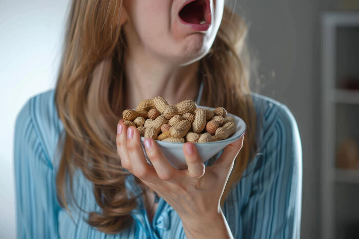 A woman with long hair recoils from a bowl of peanuts, symbolizing unexpected life story endings.