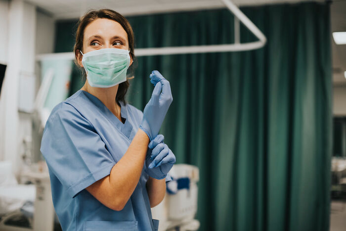 A medical professional putting on gloves before a standard medical procedure, emphasizing medical procedures.