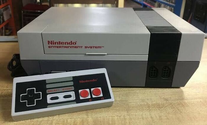 A vintage Nintendo Entertainment System (NES) console with its classic controller, quintessential 80s retro tech.