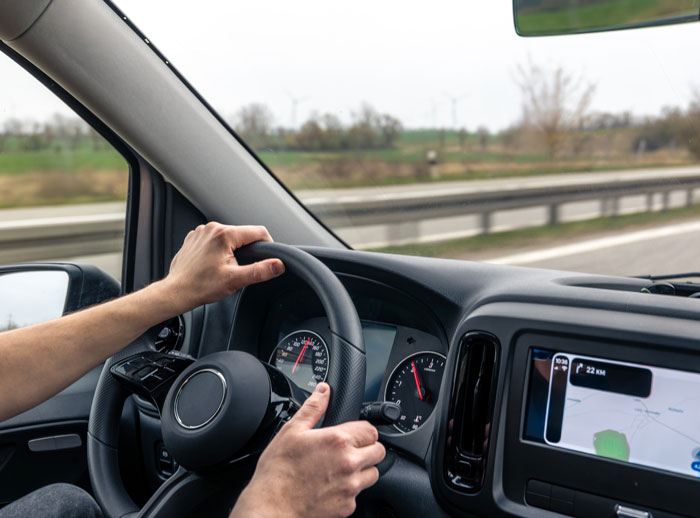 Hands on a steering wheel, showcasing karma in action.