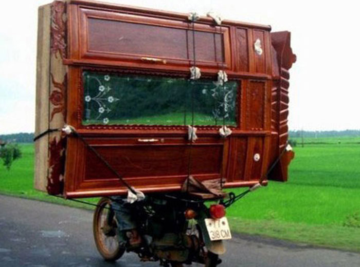 Moving fails photo of large wooden cabinet improperly secured on motorcycle