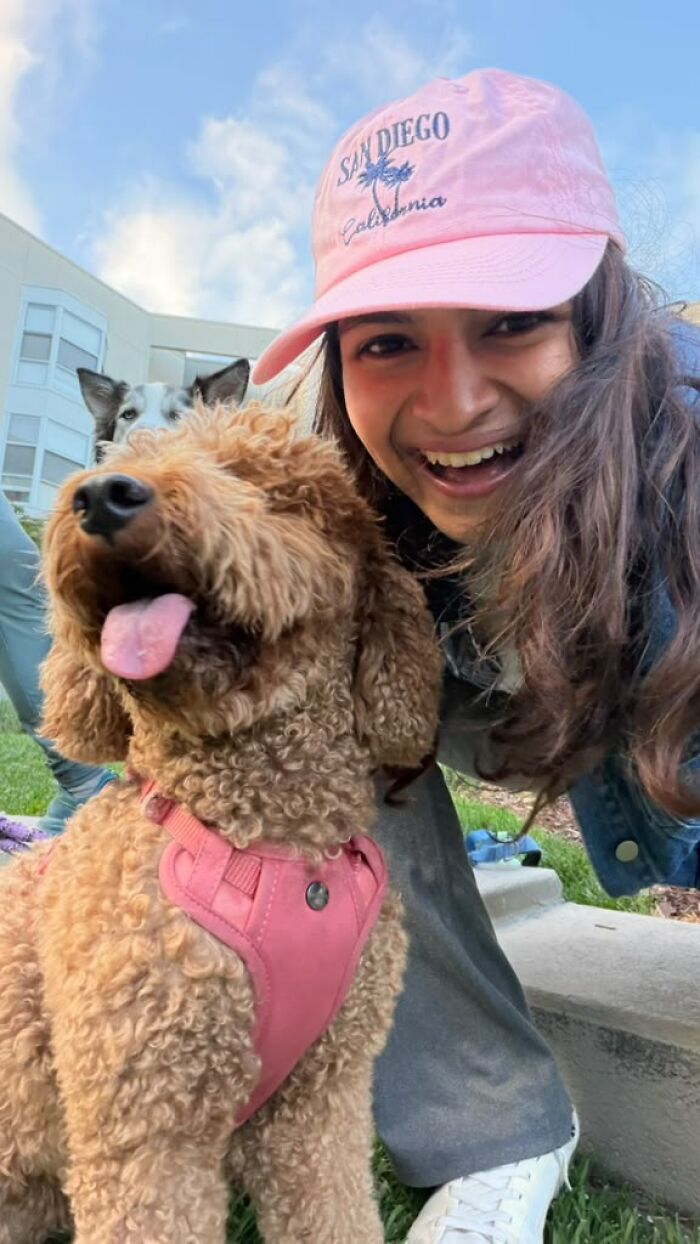 A woman smiling with her dog, helping pet owners bond and create community. A woman smiling with her dog, helping pet owners bond and create community.