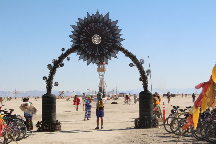 A large outdoor art installation with people walking around, symbolizing simple joys in art and community.