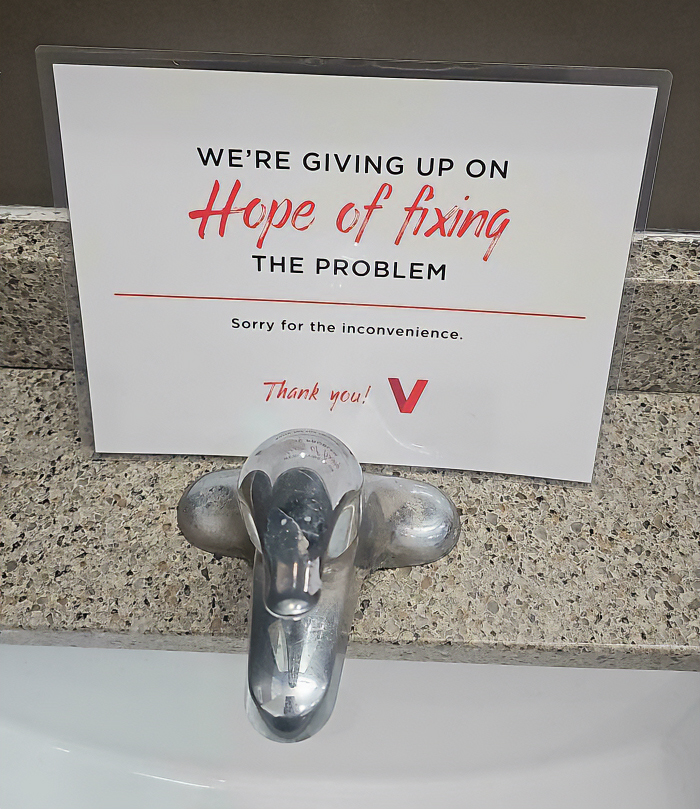 A chaotic sign above a sink tap says, We're giving up on Hope of fixing THE PROBLEM. Sorry for the inconvenience.