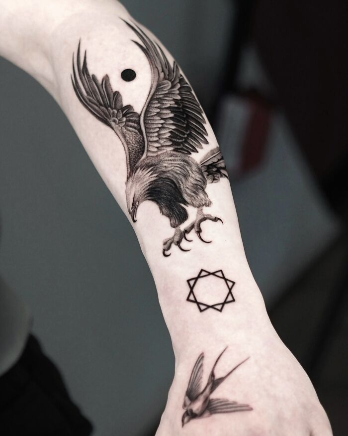 Detailed black ink eagle tattoo with bird and star symbol on arm