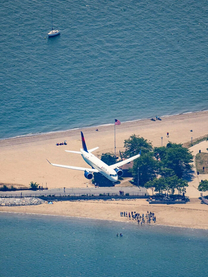A Delta airplane flying low over a beach, an illusion that might make you look twice to understand.
