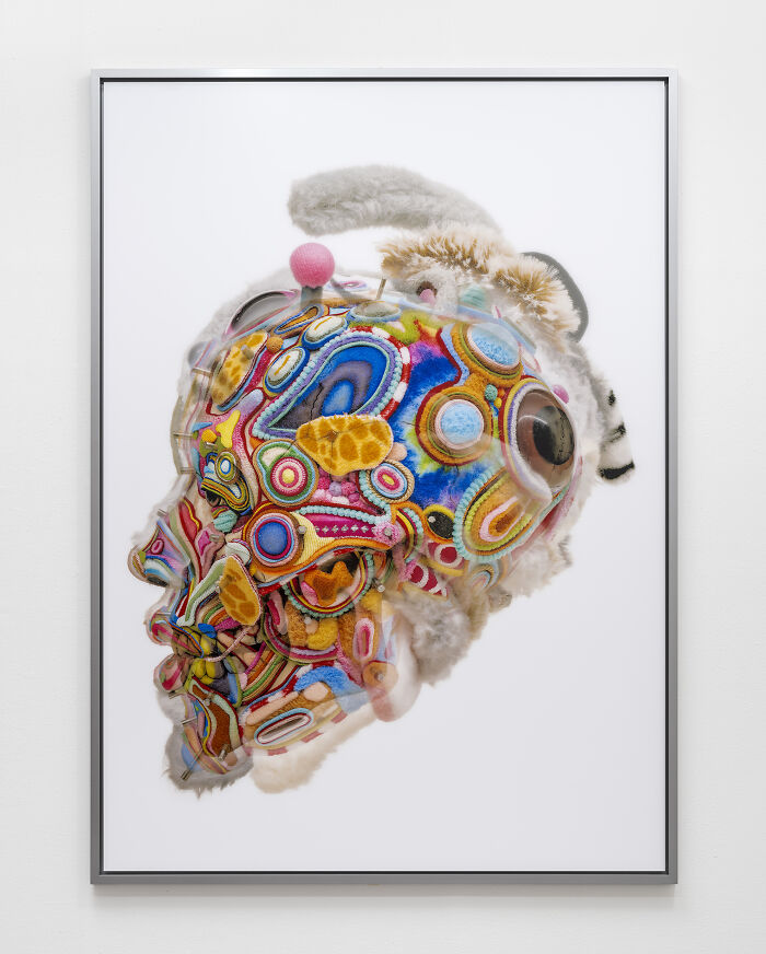 A vibrant piece from unusual sculptures depicting a head covered in intricate multicolored thread patterns