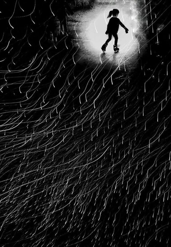 Taylor Coble street photo featuring a silhouetted figure walking in a bright light with motion blur, creating a visual story.