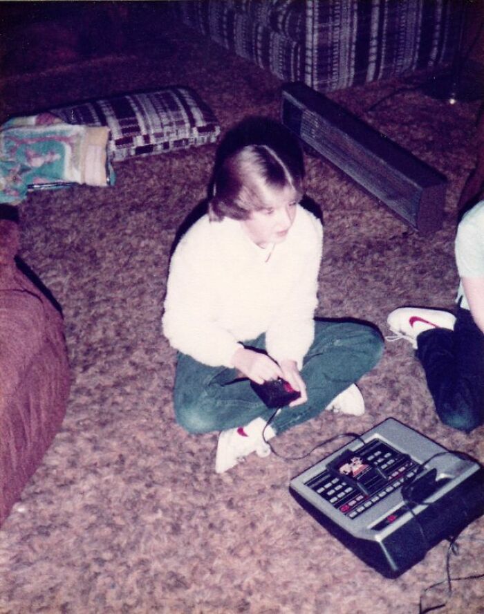 Child playing retro video game console on carpeted floor