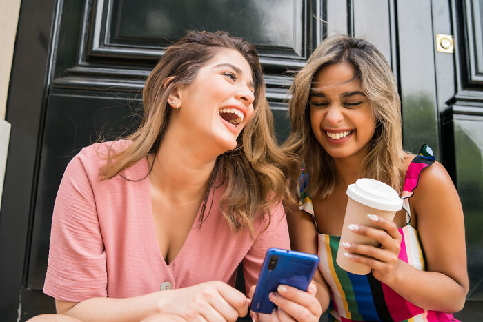Two happy women laughing together outdoor, expressing no marriage regrets