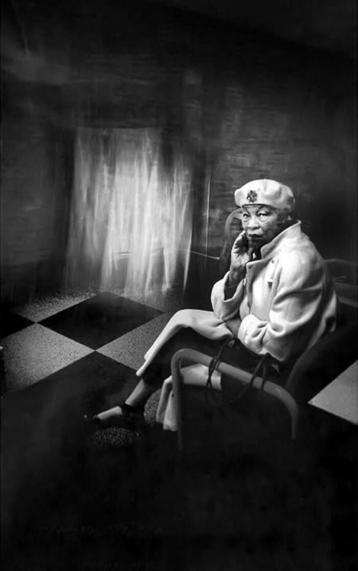 Monochrome street photo by Taylor Coble depicting an elderly woman in a beret sitting in a dramatic setting.