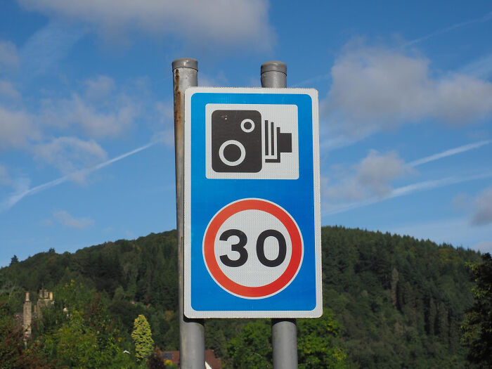 A speed camera sign indicating a 30 mph limit, crucial for road users to understand different camera types.