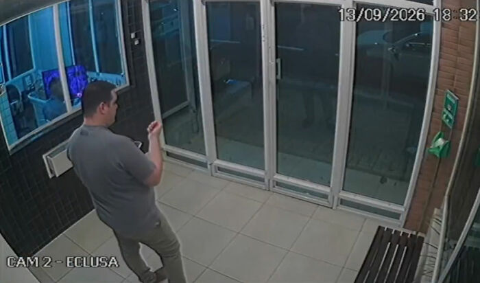Dating her boss story: security camera capture of a man in a gray shirt standing by glass doors Dating her boss story: security camera capture of a man in a gray shirt standing by glass doors