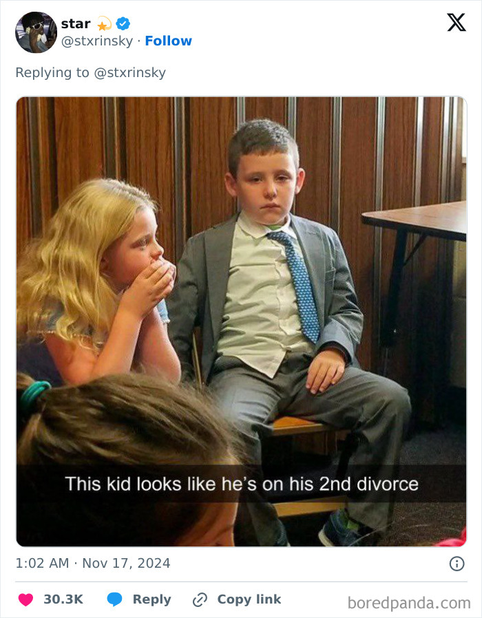 A young boy in a suit looks disgruntled, next to a girl, depicting a funny comment section moment.