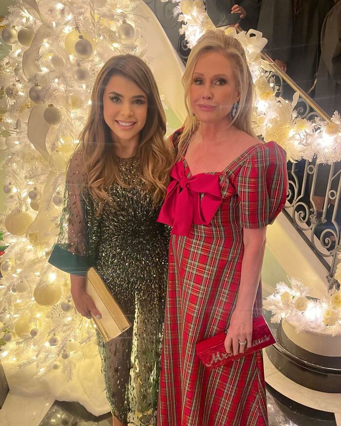 Two celebrities pose in front of a brightly lit Christmas tree, illustrating celebrity Photoshop fails.