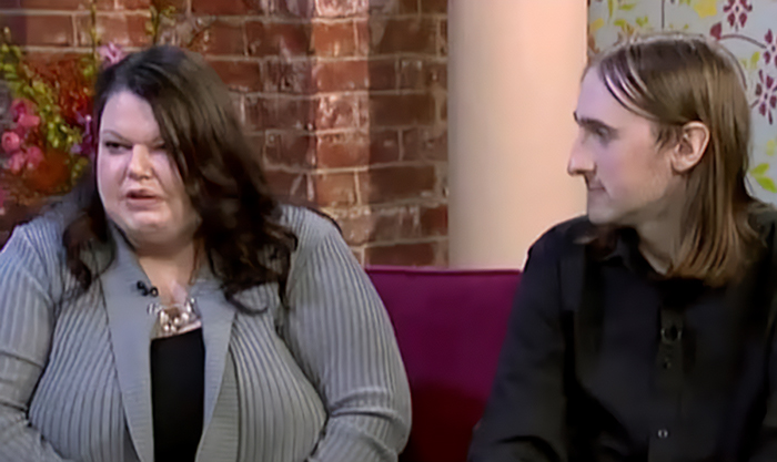 A jealous woman and her partner sitting together on a television set discussing their relationship A jealous woman and her partner sitting together on a television set discussing their relationship