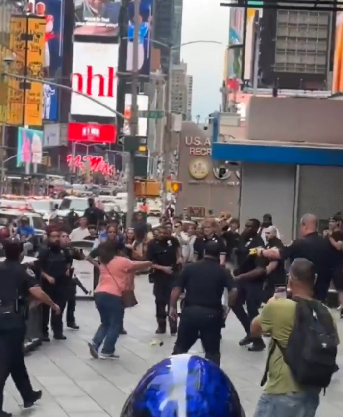 Police confront an attacker in a dramatic video, surrounded by onlookers in Times Square, victimizing a Bank of America VP. Police confront an attacker in a dramatic video, surrounded by onlookers in Times Square, victimizing a Bank of America VP.