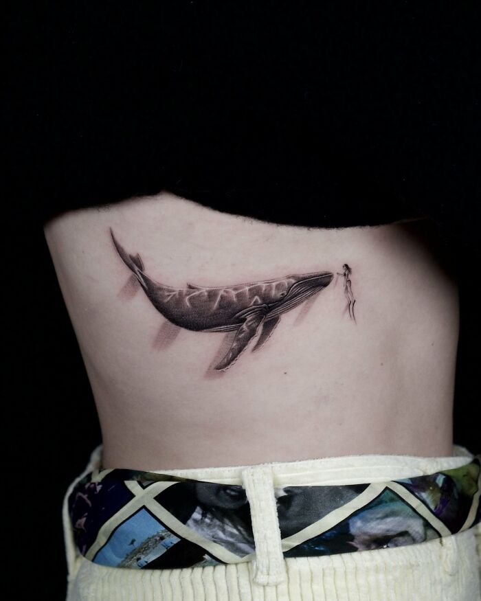 Large whale tattoo with diver on ribcage animal tattoo