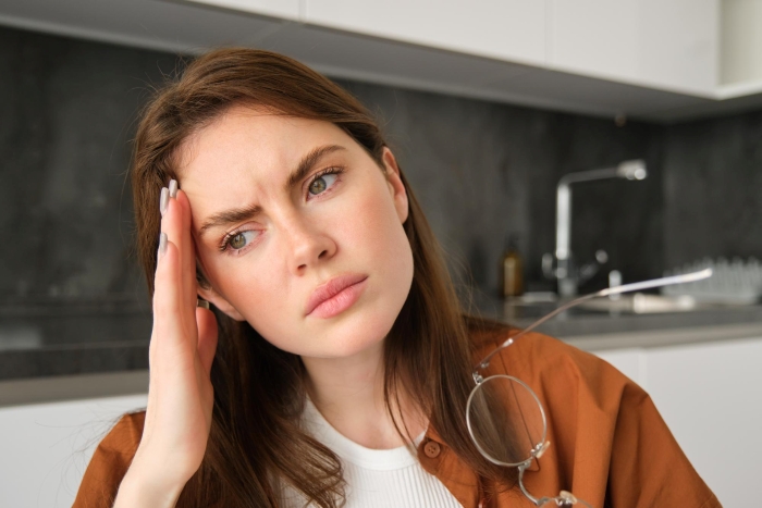 Woman looking distressed, contemplating the situation of refusing to put her life on hold for her stepsister's kid.