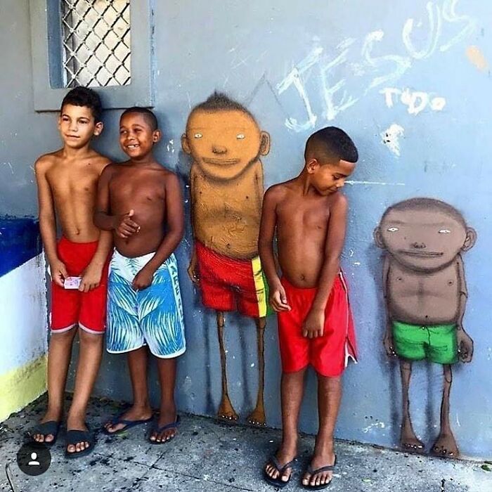 Children posing with street art drawings of figures, showcasing streets as real museums.