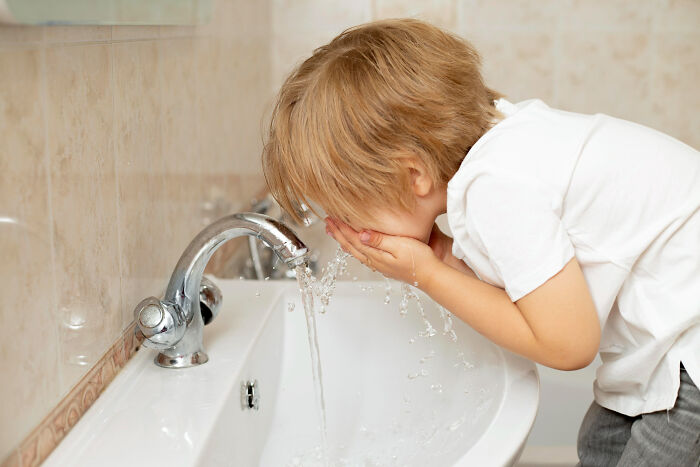 A child splashing water on their face at a sink, possibly leading to an unexpected end to a life story.