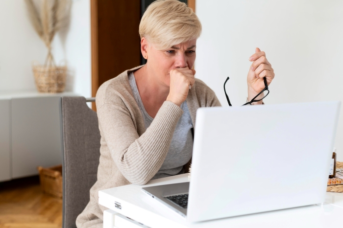 An employee looking distressed while working on a laptop, highlighting supervisors trying to make employee look bad. An employee looking distressed while working on a laptop, highlighting supervisors trying to make employee look bad.
