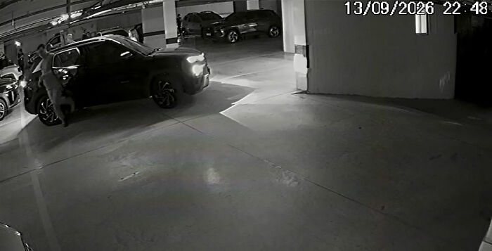 Security camera footage showing a dark SUV parked in a garage Security camera footage showing a dark SUV parked in a garage