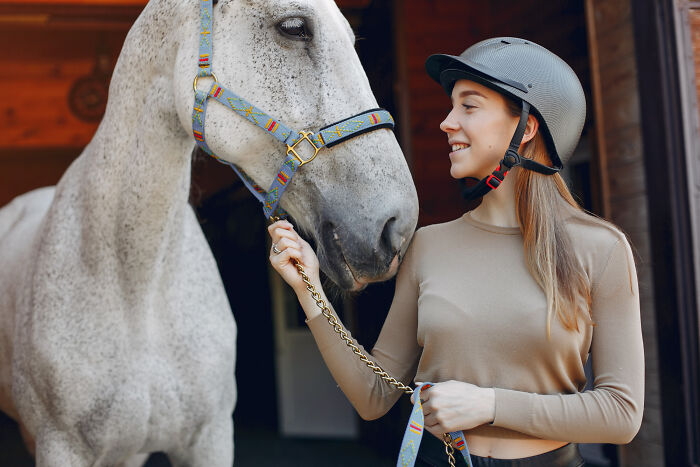 A woman wearing a helmet with her horse, unaware of the unexpected end to a life story.