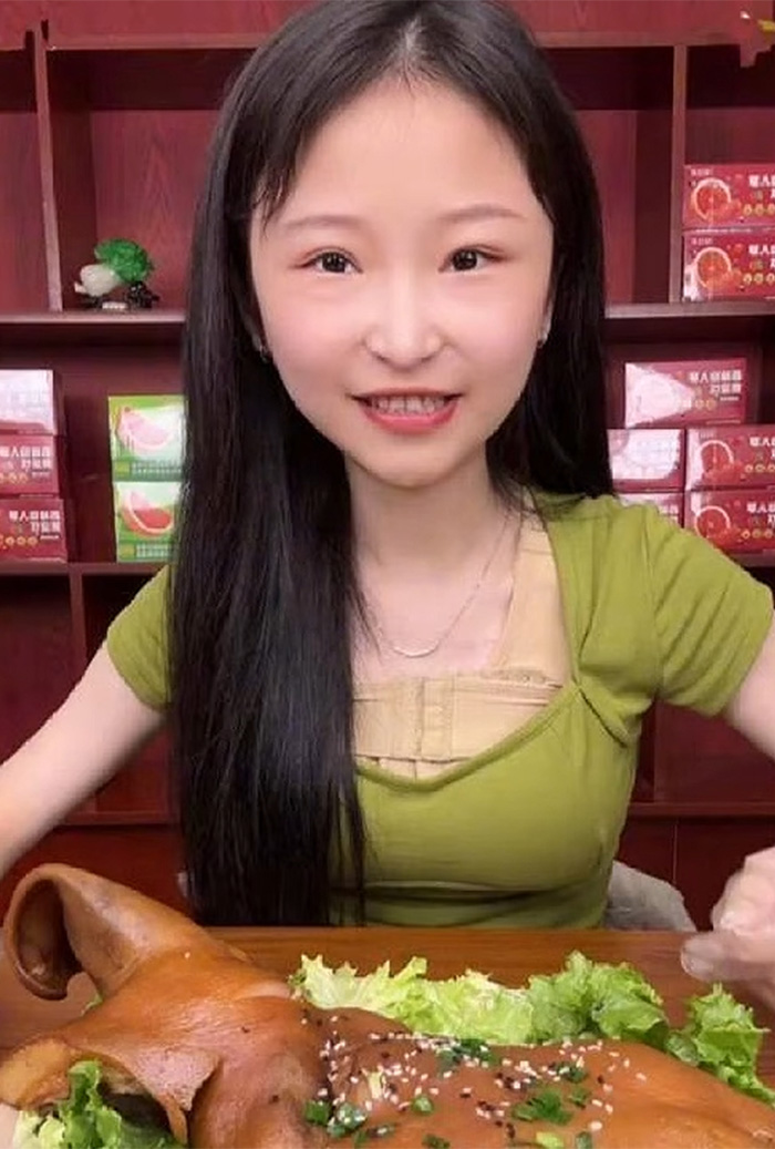 A mukbang star posing with a large meal, exemplifying the extreme eating leading to a dangerous condition.