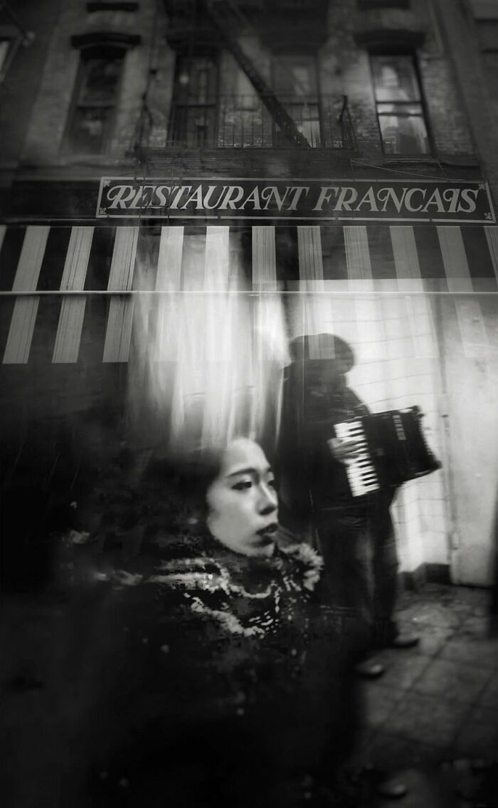 A blurred street photo of a woman in the foreground with an accordion player in the background, a visual story.