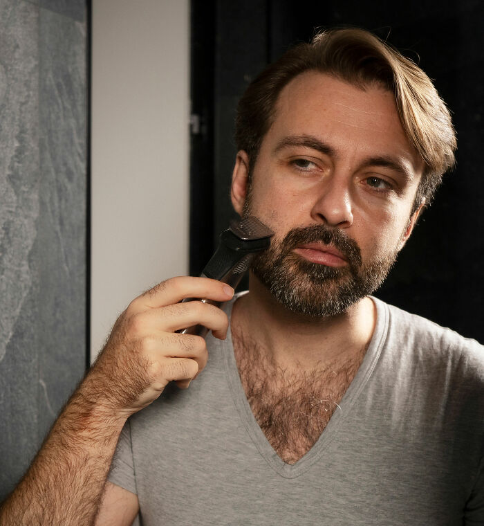 A man trimming his beard while looking in the mirror, reflecting on why marriages couldn’t be saved