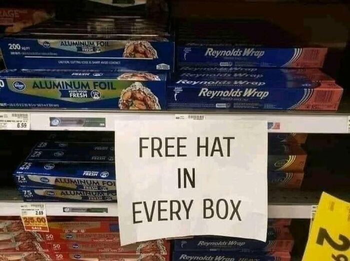 A funny sign on a shelf of aluminum foil: FREE HAT IN EVERY BOX. Silly funny signs in a store aisle.