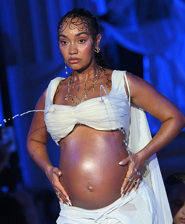A pregnant star on runway wearing a white outfit and showcasing gushing liquid