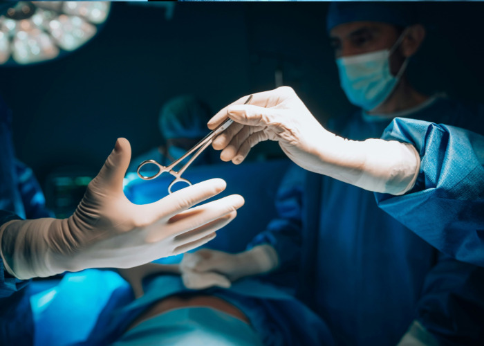 Surgeons exchanging surgical instrument during operation in hospital