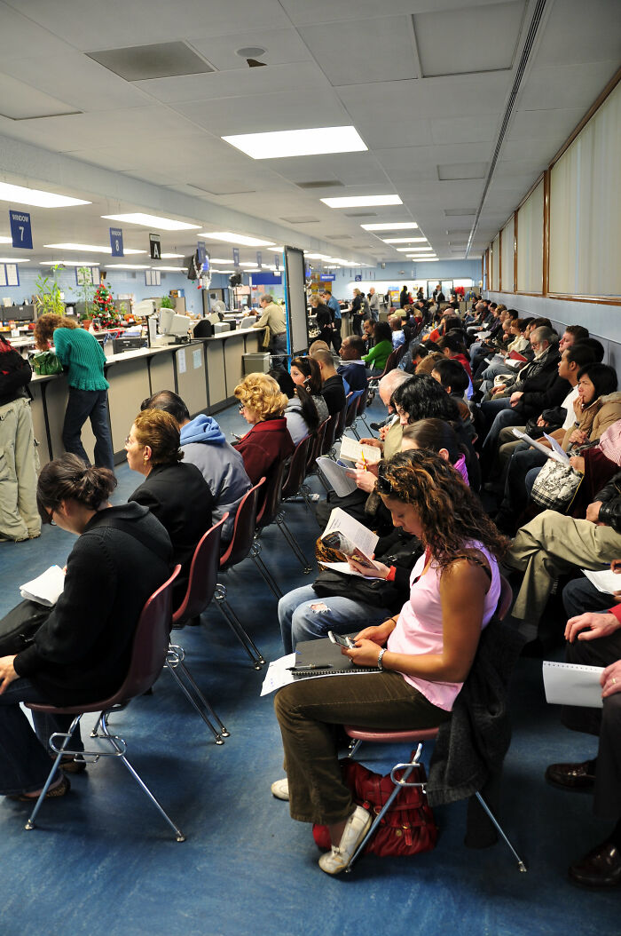 People waiting in long lines at a DMV, a stereotype about the US.