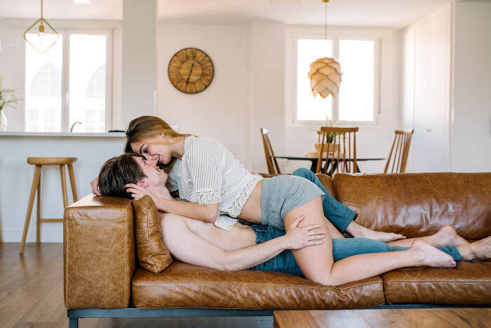 A couple affectionately embracing on a couch, avoiding the dumb ways people ruin their lives.