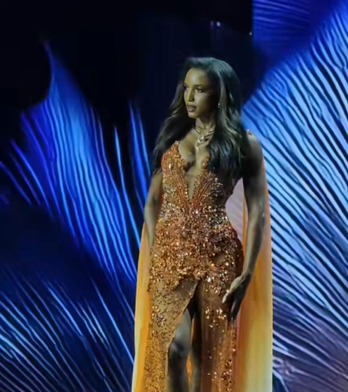 Miss Universe Jamaica Gabrielle Henry walking the stage in a sparkling orange evening gown at pageant Miss Universe Jamaica Gabrielle Henry walking the stage in a sparkling orange evening gown at pageant
