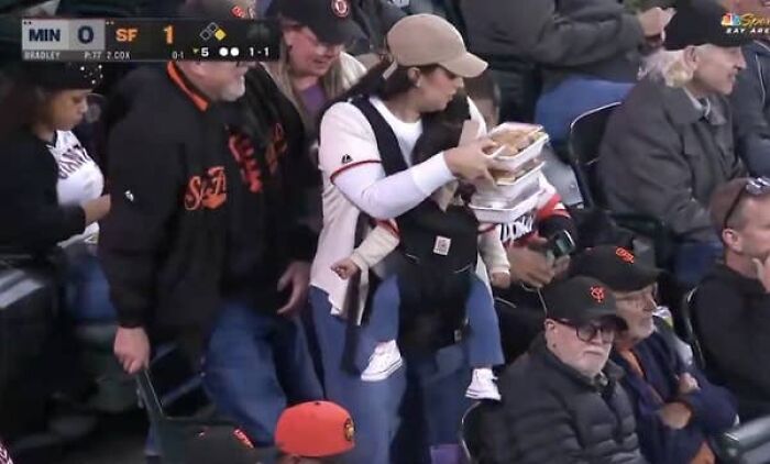 Giants fan mom carrying baby and food at baseball game