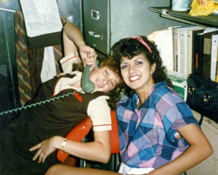 Two women smiling, one on a landline phone, showcasing 80s retro tech and glorious weirdness.