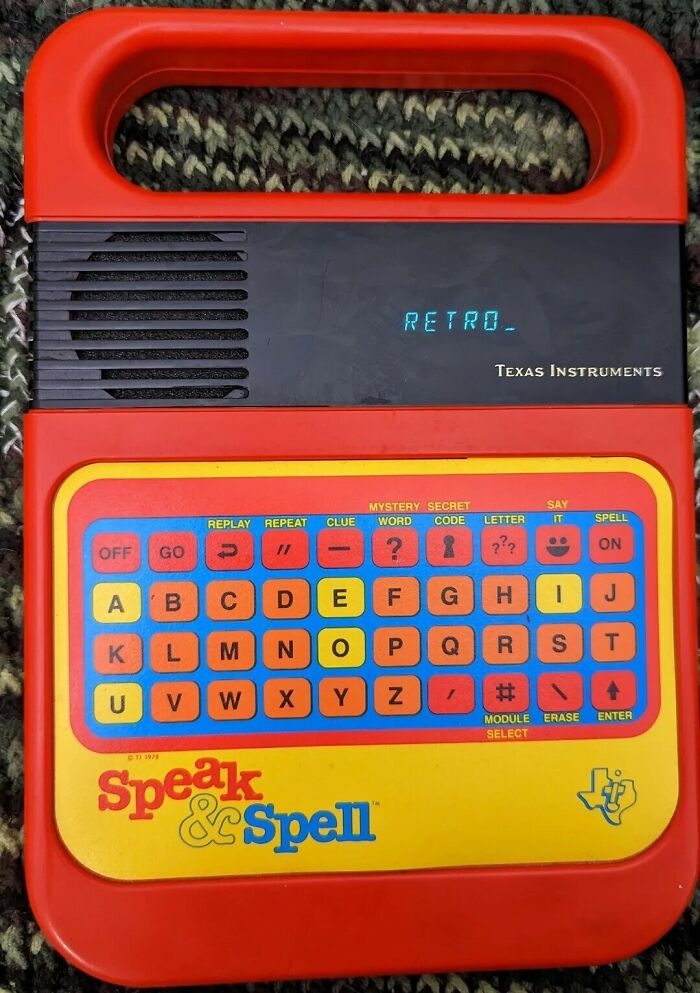 A Texas Instruments Speak & Spell, a quintessential piece of 80s retro tech, with its colorful keyboard and screen displaying retro.
