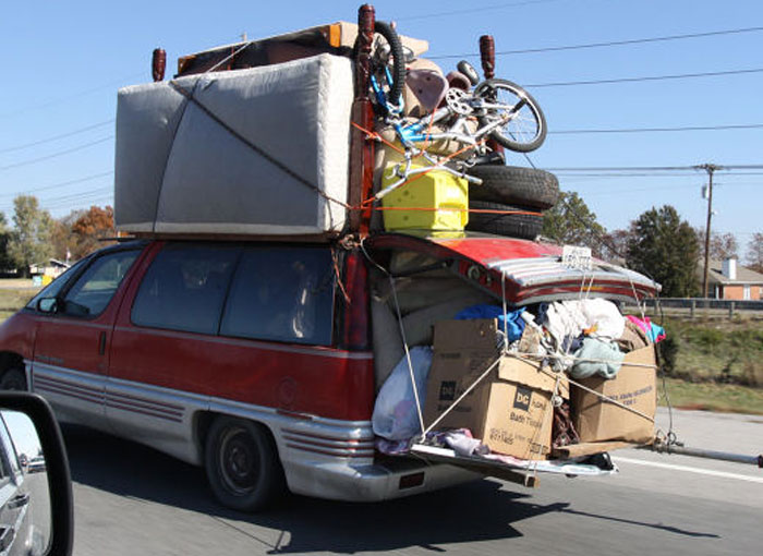 Van overloaded with furniture and boxes tied on roof and rear during moving fails pics
