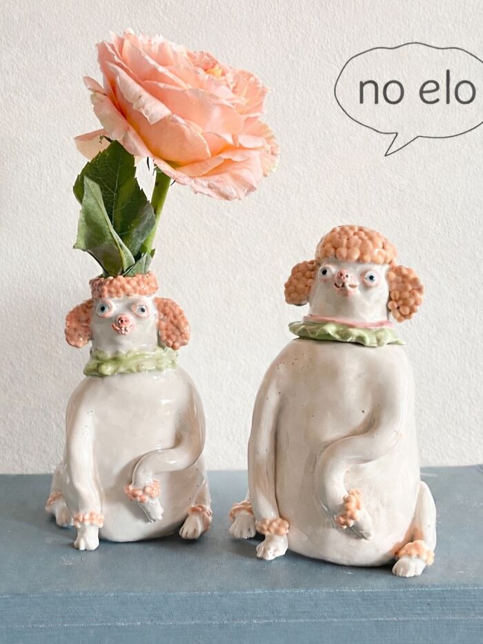 Pair of dog-shaped ceramic sculptures, one serving as a flower vase, showcasing adorable weird home decor.