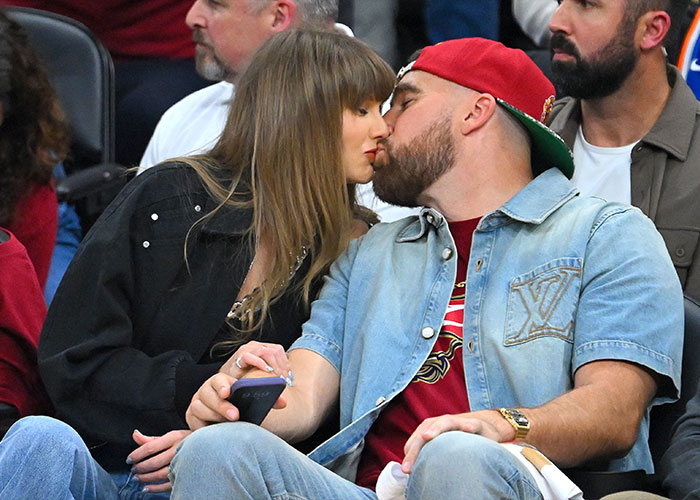Taylor Swift and Travis Kelce sharing a kiss at an event Taylor Swift and Travis Kelce sharing a kiss at an event