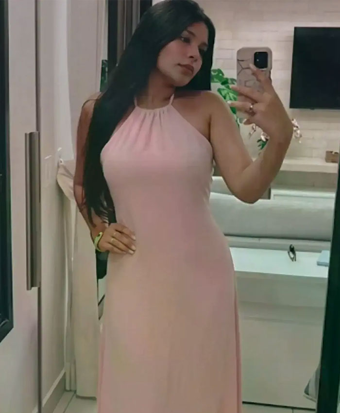 A 22YO daughter taking a mirror selfie in a pink halter dress. A 22YO daughter taking a mirror selfie in a pink halter dress.