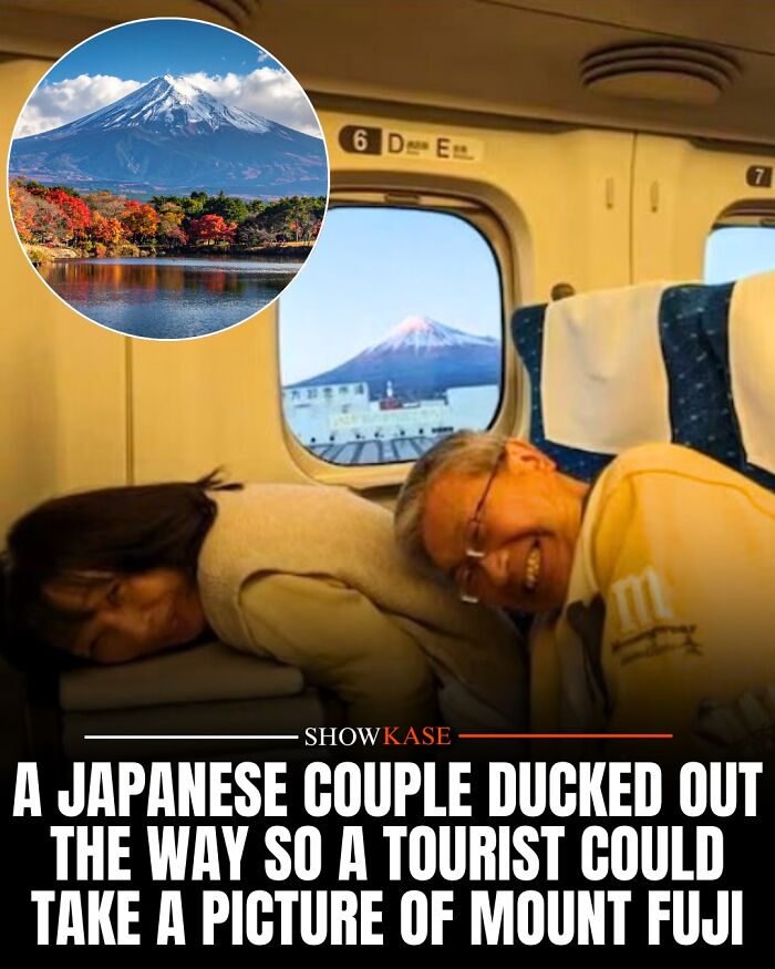 A Japanese couple ducking down on a train to let a tourist photograph Mount Fuji, showing wholesome stories.