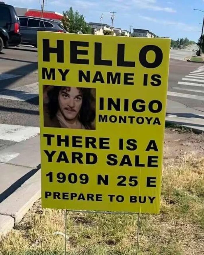 A funny sign for a yard sale features a picture of Inigo Montoya saying, HELLO MY NAME IS INIGO MONTOYA. There is a yard sale. PREPARE TO BUY.